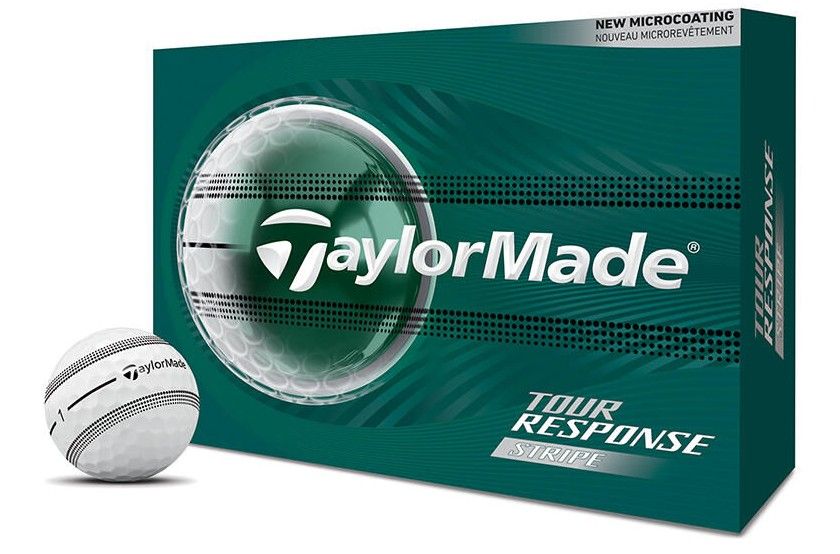 Ein weißer TaylorMade Golfball mit schwarzen Streifen und Logo liegt links vor einer dunkelgrünen Verpackung. Die Box zeigt das TaylorMade-Logo im transparenten Kreis, "Tour Response Stripe" und "NEW MICROCOATING" oben rechts.