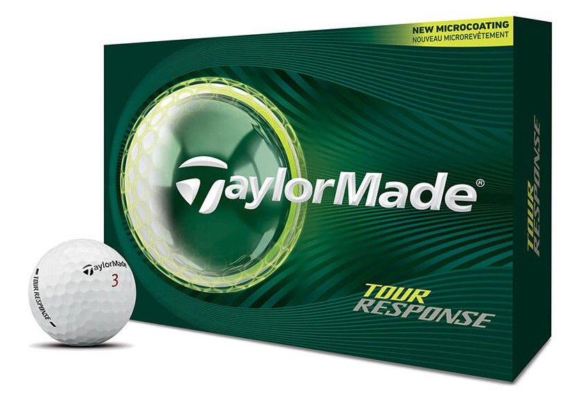Une balle de golf blanche « TaylorMade » Tour Response devant un emballage vert foncé orné d’un logo et d’un motif vert. En haut, une bande jaune indiquant le micro-revêtement.